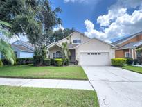 Charming two-story home boasts a manicured lawn, inviting curb appeal, and a two car garage at 2160 Brandon Park Cir, Brandon, FL 33510