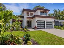 Modern two-story home featuring a well-manicured lawn, decorative plants, and a two-car garage at 2182 Wisteria St, Sarasota, FL 34239