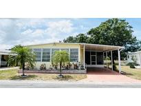 Charming single-story home featuring a covered carport, mature landscaping, and a well-maintained exterior at 3318 Oakwood S Blvd, Sarasota, FL 34237
