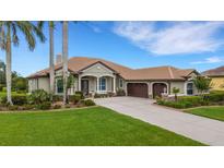 Charming single-story home with a tile roof, lush landscaping, a paver driveway and a two-car garage at 385 165Th Ne Ct, Bradenton, FL 34212