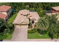 Stunning aerial view of the house showcasing its tile roof, three car garage, and lush landscaping at 4584 Tuscana Dr, Sarasota, FL 34241
