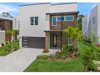 Modern two-story home boasting a sleek design, dark garage door, and beautifully landscaped front yard at 4726 Rivetta Ct, Sarasota, FL 34231