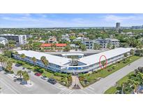 An aerial view of a condo building with a courtyard pool, lush landscaping, and convenient parking at 475 Benjamin Franklin Dr # 211, Sarasota, FL 34236