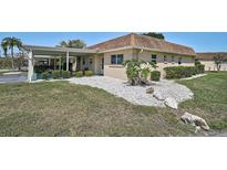 Cozy home with a carport, manicured bushes, rock garden, and well-maintained grassy lawn at 602 Park Cir, Bradenton, FL 34207