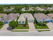 A beautiful single-Gathering home with lush landscaping, and a paver driveway, in a desirable neighborhood at 7717 Sandhill Lake Dr, Sarasota, FL 34241