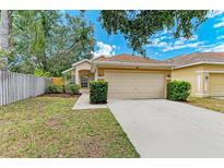 Well-maintained single-Gathering home with a lush green lawn and a two-car garage at 7885 Bristol Park Dr, Apollo Beach, FL 33572