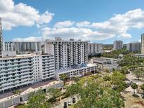 An exterior shot of the condos with a pool and beautiful landscaping in the background at 101 S Gulfstream Ave # 6C, Sarasota, FL 34236