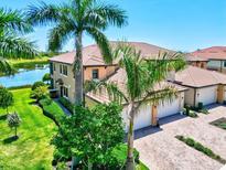 Stunning aerial view of a well-maintained home with manicured lawns and a picturesque lake nearby at 23528 Awabuki Dr # 101, Venice, FL 34293