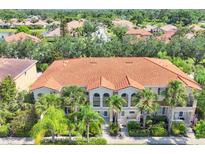 An aerial view of a residential building with a red tile roof and lush green landscaping at 3760 82Nd Avenue E Cir # 102, Sarasota, FL 34243