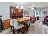 Inviting living room featuring hardwood floors, a stylish dining table, and comfortable seating arrangement at 4189 Heron Way # 406E, Bradenton, FL 34205