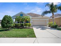 Charming single-story home with a well-manicured lawn, two car garage, and tropical landscaping at 4718 Arbor Gate Dr, Bradenton, FL 34203