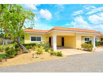Charming villa featuring a terracotta roof, mature landscaping, and a convenient covered carport at 4840 Gulf Of Mexico Dr # Villa 15, Longboat Key, FL 34228
