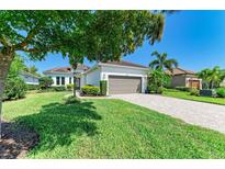 Beautiful single-story home with a well-manicured lawn, paver driveway and a neutral colored two-car garage at 5035 Tobermory Way, Bradenton, FL 34211