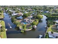 Beautiful aerial view of a canal-front home featuring a private pool and boat dock at 5500 Merrimac Dr, Sarasota, FL 34231