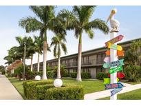 Charming beachfront hotel with lush landscaping and a whimsical pelican signpost at 7150 N Tamiami Trl # S-623, Sarasota, FL 34243