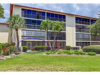 Condo building features a screened lanai, tropical landscaping, and multiple levels of resident balconies at 7500 40Th W Ave # 108, Bradenton, FL 34209