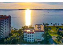 Stunning aerial view of the condo building with a glimpse of a bay at sunset at 1100 Imperial Dr # 403, Sarasota, FL 34236
