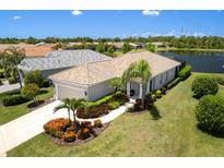 Beautiful single-story home with a tile roof, well manicured lawn and view of the lake at 12116 Stuart Dr, Venice, FL 34293