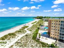 Beautiful aerial view of the beach with the condo pool and turquoise ocean waters at 1255 Tarpon Center Dr # 309, Venice, FL 34285