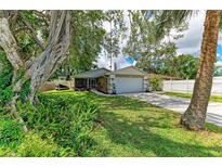 Charming single-story home with a well-manicured lawn, mature trees, and a two-car garage on a sunny day at 4115 2Nd Nw Ave, Bradenton, FL 34209