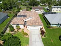 Charming home featuring a terracotta-tiled roof, screened lanai, and well-manicured landscaping at 4804 Jacaranda Heights Dr, Venice, FL 34293