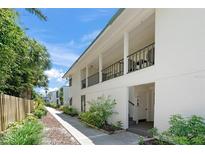 Inviting condo exterior with lush landscaping and a walkway leading to the entrance at 5681 Midnight Pass Rd # 104, Sarasota, FL 34242