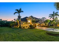 Beautiful two-story home with a lush lawn and meticulous landscaping at dusk at 6907 47Th E Ct, Ellenton, FL 34222