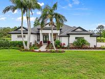 Beautiful single-story home with a well-manicured lawn and tropical landscaping, including palm trees at 7832 Panther Ridge Trl, Bradenton, FL 34202