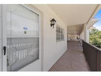 Condo entryway featuring a secure door, hallway, and decorative lighting at 860 Virginia St # 304, Dunedin, FL 34698