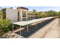 Exterior shot of covered parking with building and landscape in the background at 860 Virginia St # 304, Dunedin, FL 34698