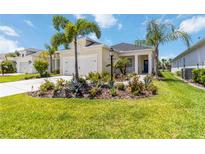 Charming home with a well-manicured lawn, lush landscaping, and inviting front entrance at 10926 Sand Pine Ln, Parrish, FL 34219
