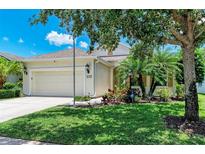Charming single-story home with a well-maintained lawn, mature trees, and an attached two-car garage at 11811 Fennemore Way, Parrish, FL 34219