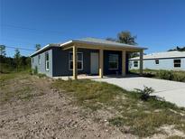Newly constructed single-Gathering home showcasing a covered entrance and a concrete driveway at 1227 30Th W Ave, Bradenton, FL 34205