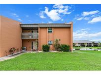 Two-story condo featuring a well-maintained lawn, vibrant landscaping and a balcony overlooking the grounds at 1355 Rock Dove Ct # 1-2, Punta Gorda, FL 33950