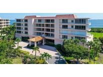 Beautiful exterior shot of this condo building, including entrance and meticulously maintained landscaping with mature palms at 3070 Grand Bay Blvd # 644, Longboat Key, FL 34228