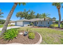 Charming single-story home with a well-manicured lawn, lush landscaping, and an attached two-car garage at 3335 Meadow Run Ter, Venice, FL 34293