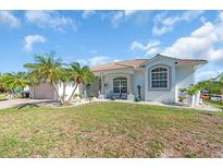 Charming single-story home featuring a tile roof, lush landscaping, and a two-car garage at 3620 Como St, Port Charlotte, FL 33948