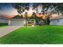 Charming single-story home featuring a manicured lawn and lush landscaping at 5386 Creekside Trl, Sarasota, FL 34243