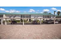 Exterior view of condo's parking with ample covered parking spaces and well-maintained brick driveway at 5623 Midnight Pass Rd # 615, Sarasota, FL 34242