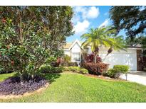 Charming home featuring lush landscaping, healthy green lawn, and a variety of plants and flowers at 5812 Garden Lakes Fern, Bradenton, FL 34203