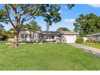 Charming single-story home with a lush green lawn, mature tree, and well-maintained landscaping at 5900 6Th S Way, St Petersburg, FL 33705