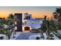 Striking modern home featuring clean lines, a rooftop deck, lush landscaping, and a paver driveway at 6381 Gulf Of Mexico Dr, Longboat Key, FL 34228