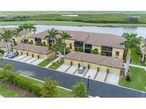 Scenic aerial view of condo community with lush landscaping, lake views, and tile roofs at 7235 River Hammock Dr # 204, Bradenton, FL 34212