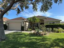 Charming home featuring well-maintained landscaping, lush green lawn, and a welcoming entrance at 10116 Reagan Dairy Trl, Bradenton, FL 34212
