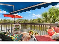 Inviting deck with an awning, colorful seating, and peaceful water views at 1312 Perico Point Cir, Bradenton, FL 34209