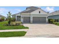 Charming home featuring a well-manicured lawn and a two-car garage, offering both curb appeal and practicality at 13708 Old Creek Ct, Parrish, FL 34219