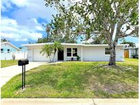 Charming single-story home with a well-maintained lawn, mature trees, and a welcoming front entrance at 1902 24Th W Ave, Bradenton, FL 34205