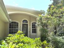 Home's inviting front entrance features arched windows and decorative shrubbery, creating a welcoming curb appeal at 2809 112Th E Ter, Parrish, FL 34219