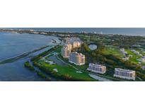 Stunning aerial view of a luxury condo community with a marina, golf course, and ocean views at 3060 Grand Bay Blvd # 182, Longboat Key, FL 34228