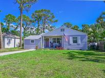Charming single-story home with well-manicured lawn, rocking chairs on porch and an American flag at 3212 Avenue A W, Bradenton, FL 34205